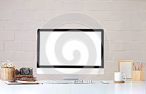Work place with blank screen computer pc and office supplies on white table with brick wall in vintage office