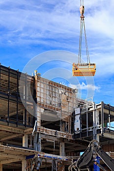 A work platform being lowered to a partially demolished building