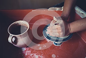Work in a pottery workshop, womans hands creating ceramics.