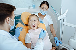 Work of professional doctor and pediatric dentist in modern clinic with equipment