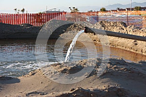 Work in progress on the sandy beach. open yard, between pipes and orange bars before the seasonal summer open sea