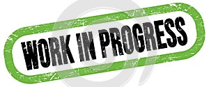 WORK IN PROGRESS, text written on green-black stamp sign