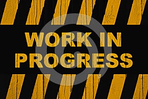 Work in progress warning sign with dark yellow orange and black stripes