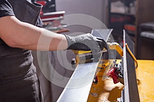 Work and repair concept - a man`s hands repairing the ski by rubbing a paraffin