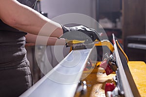 Work and repair concept - a man`s hands repairing the ski by rubbing a paraffin