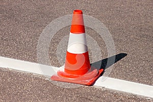 Work on road. Construction cone. Traffic cone, with white and orange stripes on asphalt. Street and traffic signs for signaling.