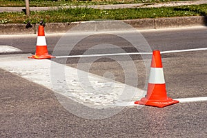 Work on road. Construction cones. Traffic cone, with white and orange stripes on asphalt. Street and traffic signs for signaling.