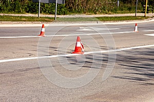 Work on road. Construction cones. Traffic cone, with white and orange stripes on asphalt. Street and traffic signs for signaling.