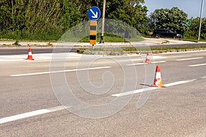 Work on road. Construction cones with traffic sign keep right sign. Traffic cones, with white and orange stripes on asphalt.