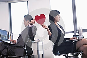 Work romance between two business people holding a heart