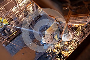 Work safety practise spotter, firewatch personal holding firehose spraying water at the conveyor belt