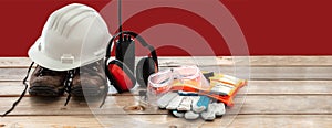 Work safety protection equipment. Industrial protective gear on wooden table, blur construction site background