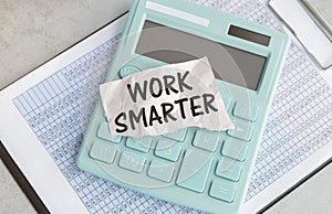 work smarter text on a pink card on the background of reports on the gray table