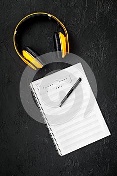 Work space of composer or dj with headphones and notes black background top view mock-up