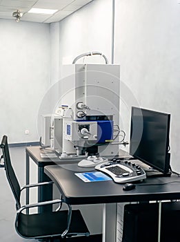 Work space of a scientist with Electron microscope, table and computer