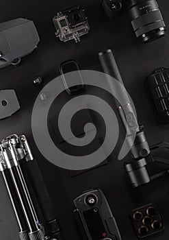 Work space videographer with laptop, digital camera, memory card, action camera, drone, remote controller, phone and camera