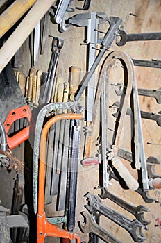 Work table of a carpenter with many tools olds hanging