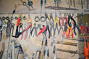 Work table of a carpenter with many tools olds hanging