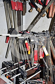 Work table of a carpenter with many tools olds hanging