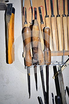 Work table of a carpenter with many tools olds hanging