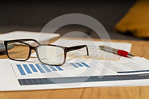 Work table at home with pen, papers, bills, charts, glasses, computer and calculator. Concept work at home, checking accounts,