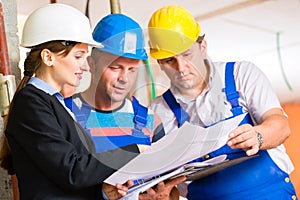 Work Team on construction site controlling floor plan