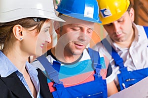 Work Team on construction site controlling floor plan