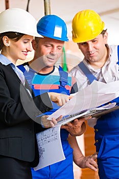 Work Team on construction site controlling floor plan