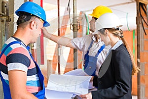Work Team on construction site controlling floor plan