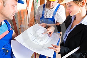 Work Team on construction site controlling floor plan