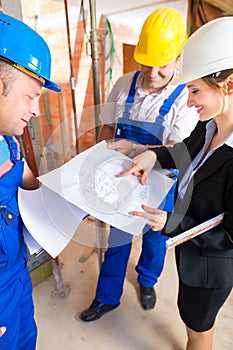 Work Team on construction site controlling floor plan