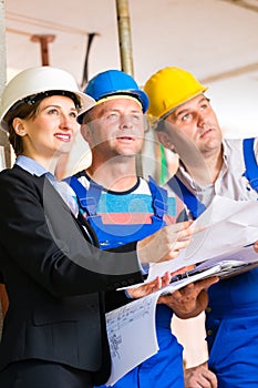 Work Team on construction site controlling floor plan