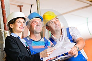 Work Team on construction site controlling floor plan