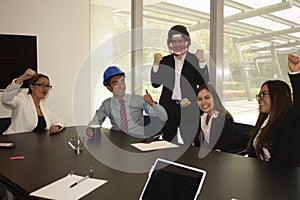 Work team excited about the attitude of its leader who wears an American helmet to empower