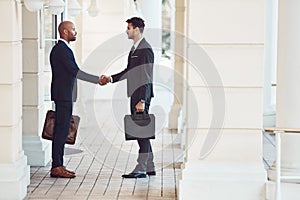 Work together and watch your profits grow. two businessmen shaking hands in the city.