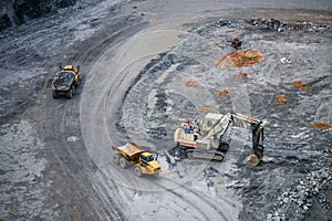 Work of trucks and the excavator in an open pit on gold mining