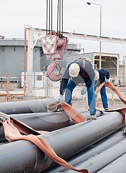 Work on unloading of pipes for construction.