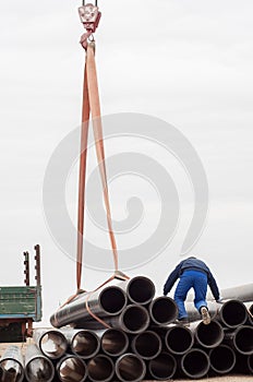 Work on unloading of pipes for construction.