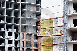 Work on weatherizing the facade of a high-rise building.