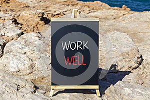 Work well symbol. Concept words Work well on beautiful black chalk blackboard. Beautiful stone sea blue background. Business