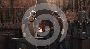 We work well under pressure. two metal workers working in a welding workshop.