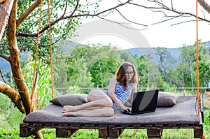 Workaholic woman working on a laptop outdoors.