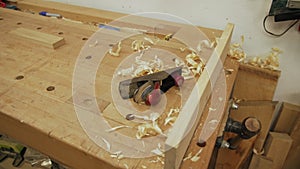 Workbench with wood shavings and tools in carpenter workshop after a busy day