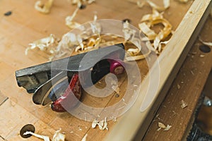 Workbench with wood shavings and tools in carpenter workshop after a busy day