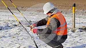 Worker with adjustable wrench near tensioner at outdoor