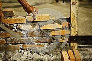 Worker adjusting cemented bricks structure