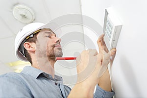 Worker adjusts digital thermostat