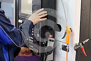 Worker adjusts the parameters of the CNC machine