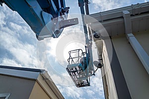 Worker on a aerial access platform, cherry picker, cleaning house