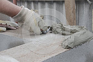 Worker aligns with a spatula lay brick cinderblocks photo